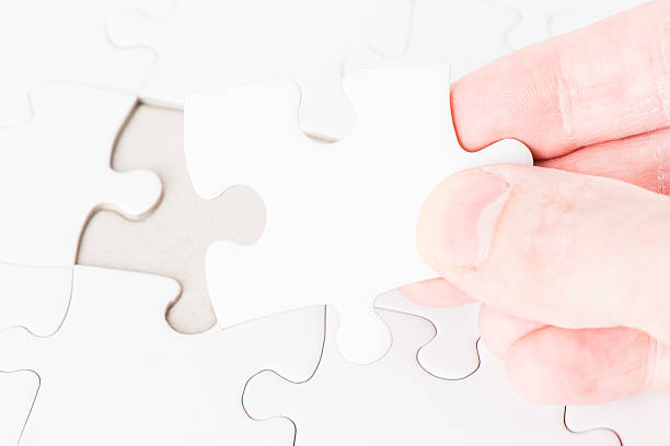 istock Hand placing the last puzzle piece 477887147