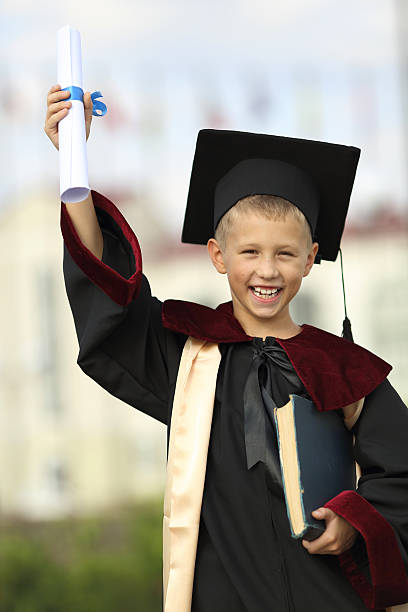 istock Boy graduate with a diploma and books 477887247