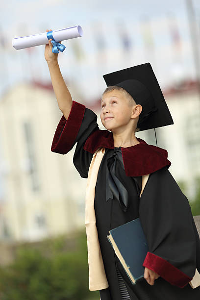istock Boy graduate with a diploma and books 477887265