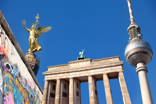 Composition of the most famous Berlin landmarks: historic Berlin Wall, Branderburg Gate, golden Victory Column and Television Tower in Alexanderplatz. Complete panorama on a blue sky with copy space. Berlin, Germany,  is one of the most exciting and cool travel destinations in Europe. 