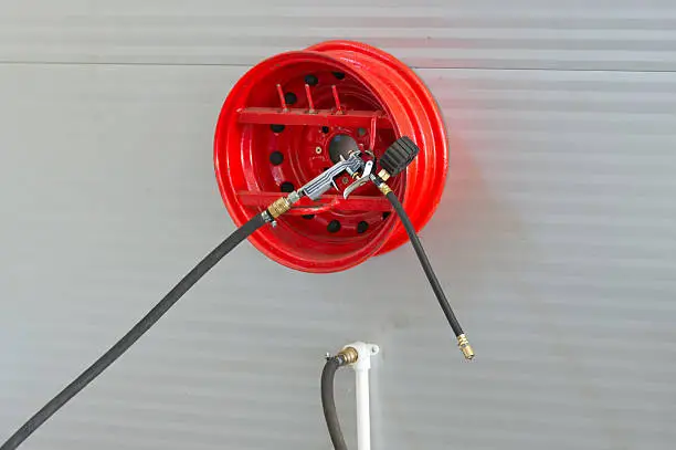 pump for car tires hangs on red rims