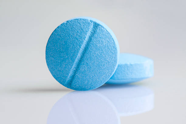 Close-up of two blue pills, taken with macro lens. 