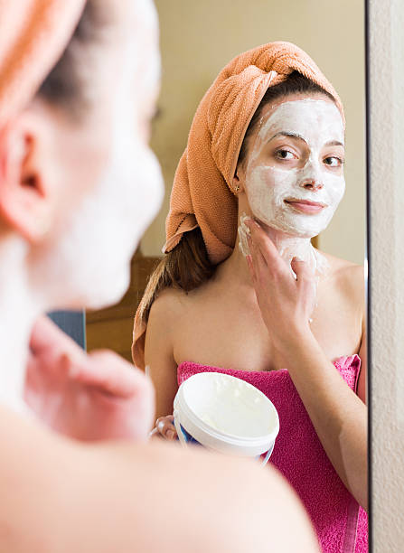 istock Girl applying cream on skin 477894110