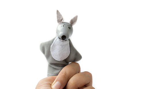 Finger puppet of wolf. Concept of kids European fairy tale Little Red Riding Hood. Isolated on white background. Copy space.