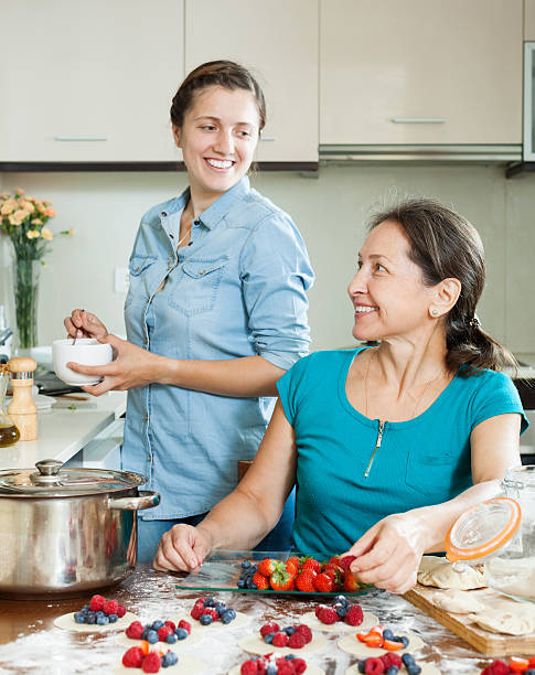 istock Two smiling women making  vareniki with berries 477895262