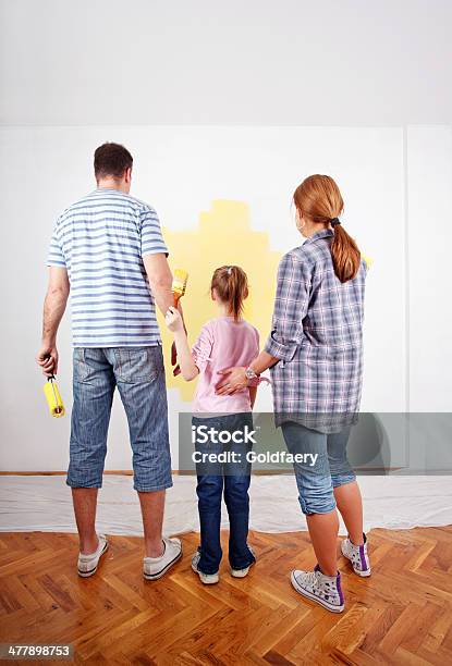 Family Looking At Paint Sample On The Wall Stock Photo - Download Image Now - 30-39 Years, Activity, Adult