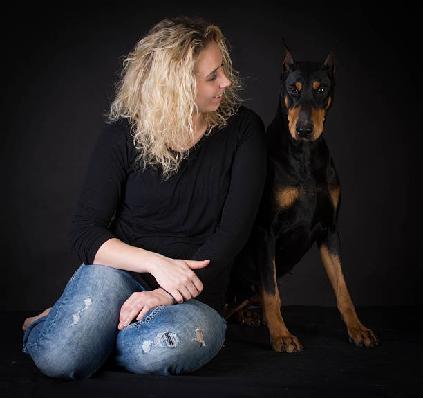 Woman staring into the face of her doberman