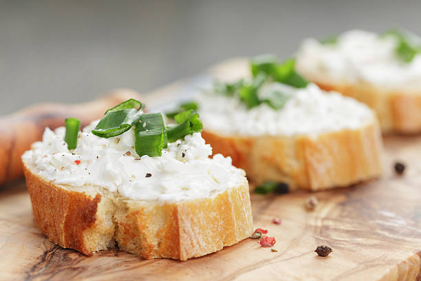 knusprige baguette scheiben mit frischkäse und frühlingszwiebeln - crostini stock-fotos und bilder