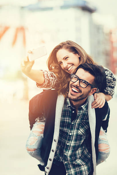istock Man piggybacks girl for a selfie 477901402