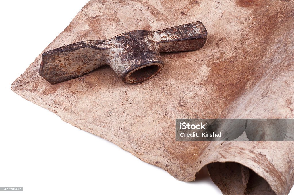 Roll of vintage parchment with old rusty hack Partially view of vintage parchment roll with old rusty hack lying on it. Close-up. Isolated on white background. Aging Process Stock Photo
