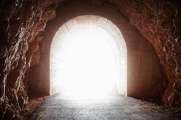 istock Glowing end of old tunnel in red rock 477901625