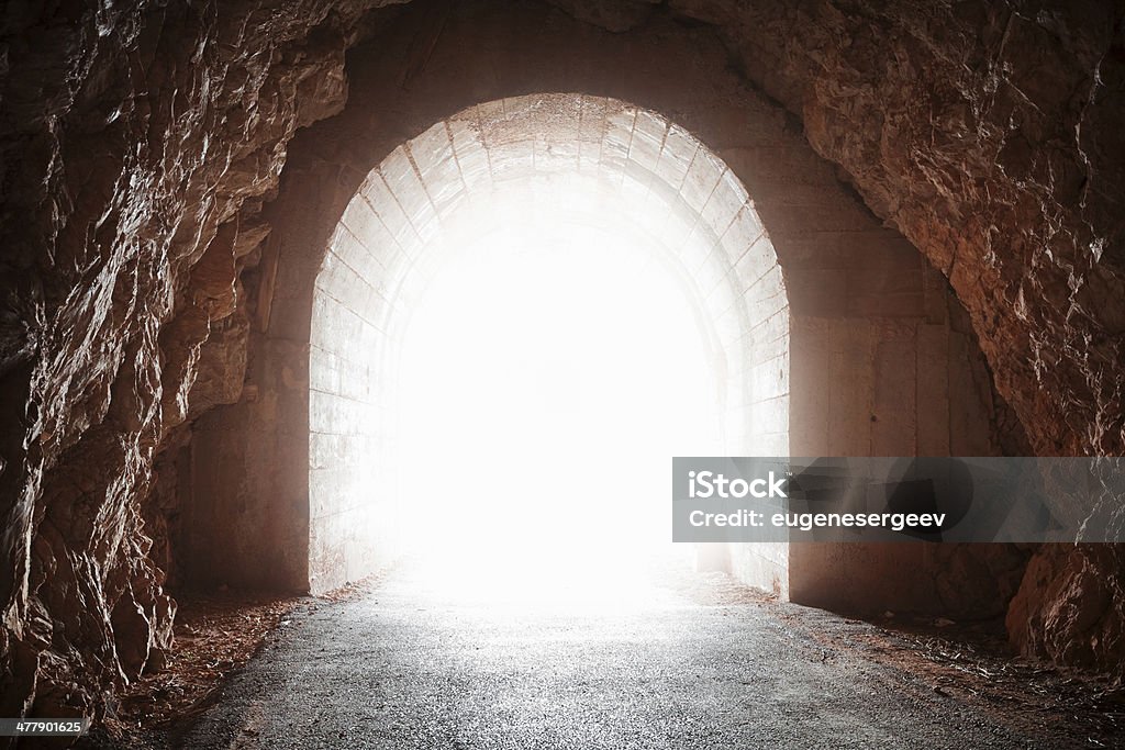 Glowing end of old tunnel in red rock Abandoned Stock Photo