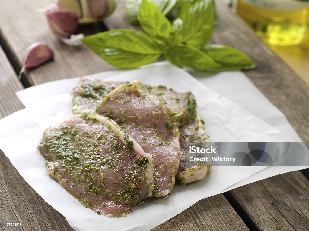marinated meat Fresh pork meat in green marinade, selective focus Basil Stock Photo