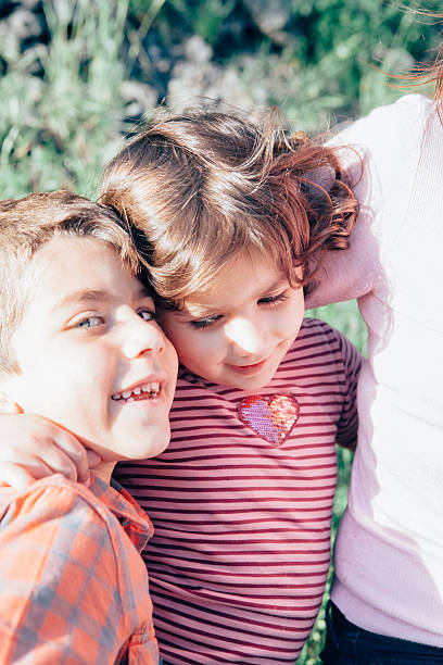 istock Mother Embracing Her Son and Daughter 477904846