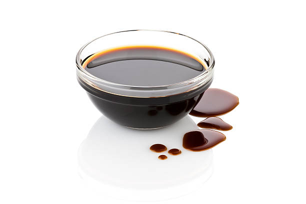 istock Balsamic vinegar in glass bowl with spills isolated on white 477905180