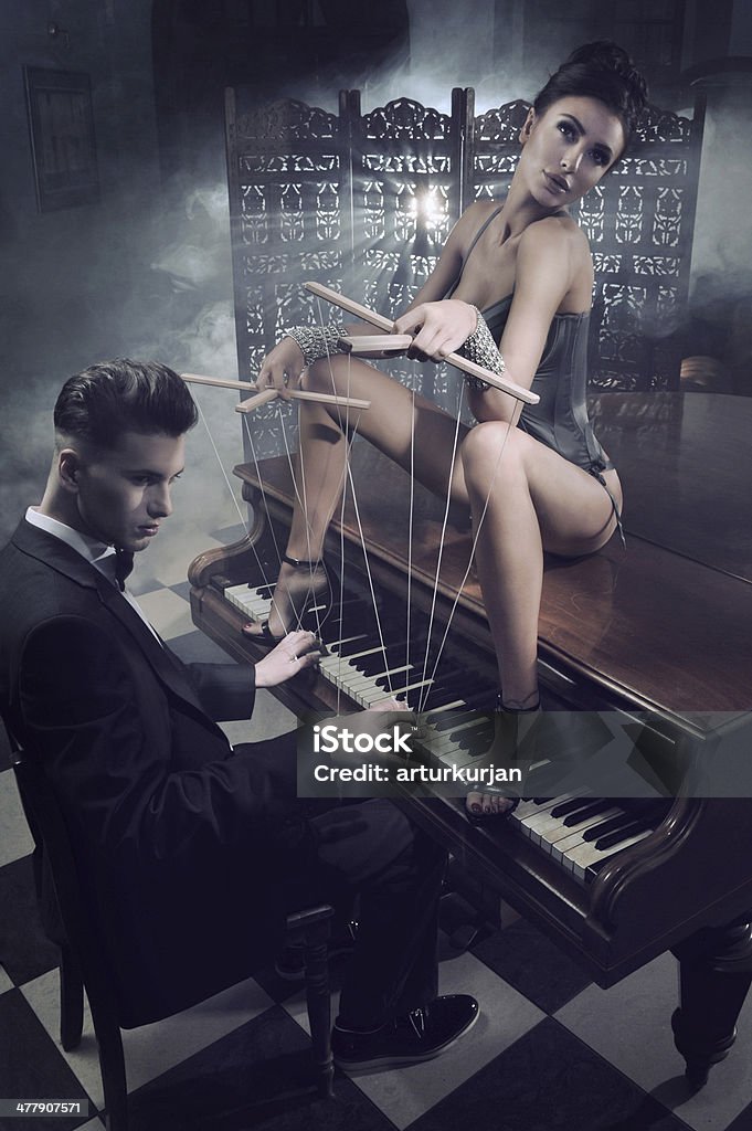 Femme sensuelle avec de la lingerie sexy assise sur un piano - Photo de Piano libre de droits