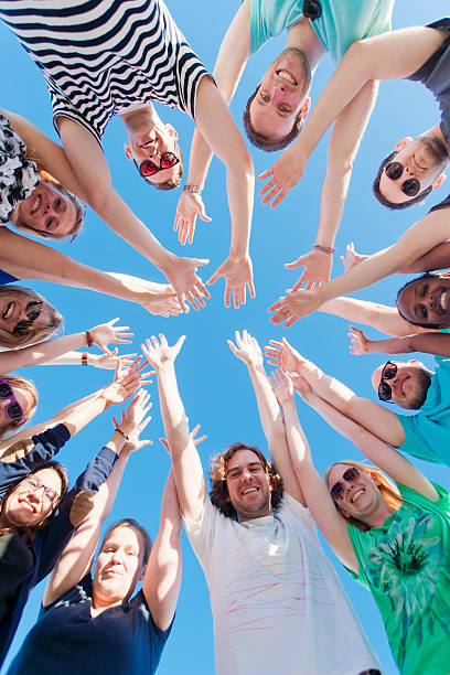 istock Young people raising hands and looking at camera 477908612
