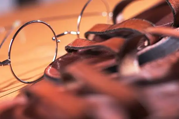 Close up of Gandhi style circular glasses and sandals.