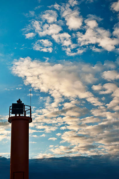 istock Beacon on cloudy blue sky background. Sunset on Baltic sea 477910433
