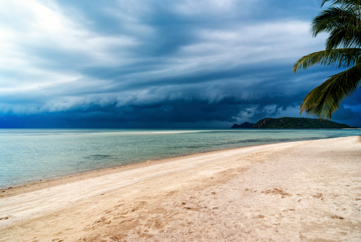 The clouds darken as a tropical storm approaches the beach.