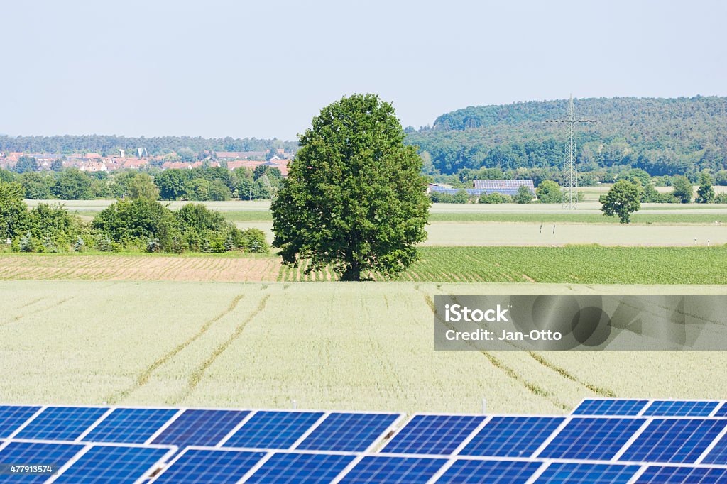 Solar cells and tree in the coutryside Lots of solar cells in the country in summer. Image taken with Canon EOS 1Ds Mark 2 and EF 70-200 mm USM L 2,8. 2015 Stock Photo