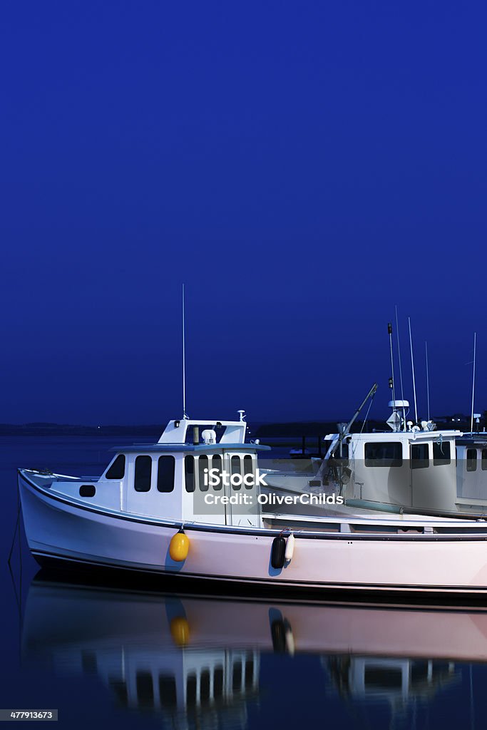 P.E.I. fishing boats at the blue hour.  Typical Prince Edward Island fishing boats photographed during the blue hour at Malpeque harbour.  Blue Stock Photo