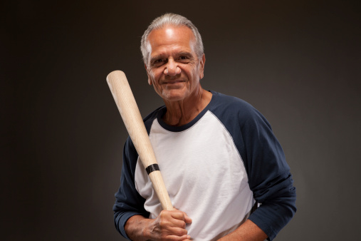 Smiling senior man with a baseball bat