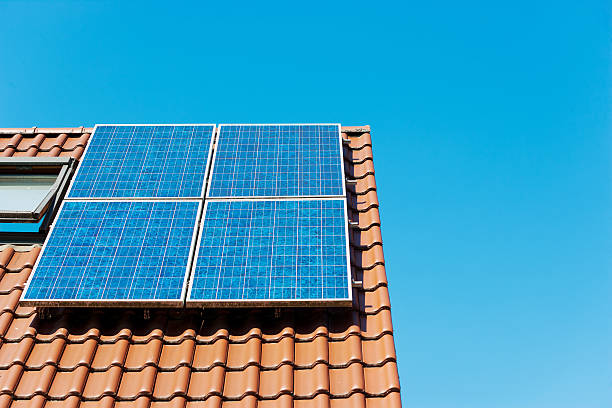 Solar panel on german rooftop against clear blue sky Close up of a solar panel on a rooftop. Lots of copy space.  Image taken with Canon EOS 1 Ds Mark 2 and EF 70-200 mm USM L 2,8. solar power station solar panel house solar energy stock pictures, royalty-free photos & images