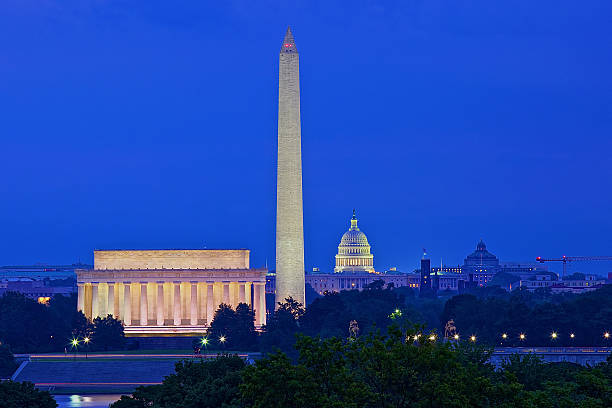 Washington, DC skyline at night; United States A skyline view of Washington, District of Columbia at dusk. The Lincoln Memorial, Washington Monument and the U.S. Capitol Building illuminate the Washington, D.C. skyline as seen from the nearby Iwo Jima Memorial in Rosslyn, Virginia. monument photos stock pictures, royalty-free photos & images
