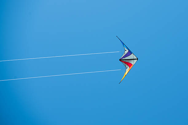 istock Colored kite with two white lines against blue background 477925464