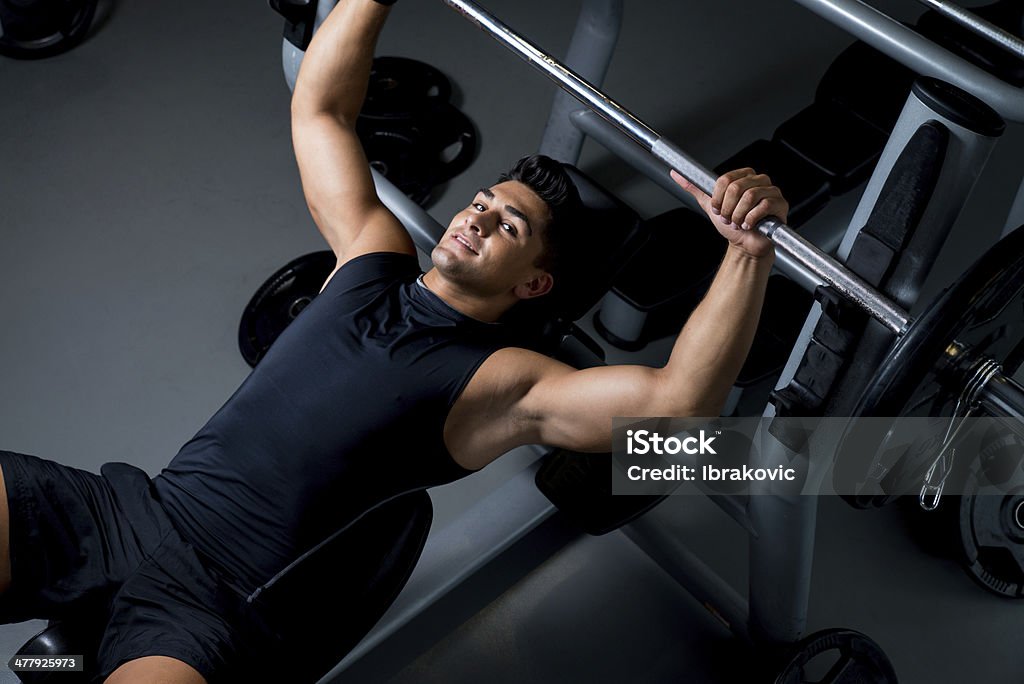 Bel giovane bodybuilder smilingly Prepara per l'esercizio - Foto stock royalty-free di Distensione su panca