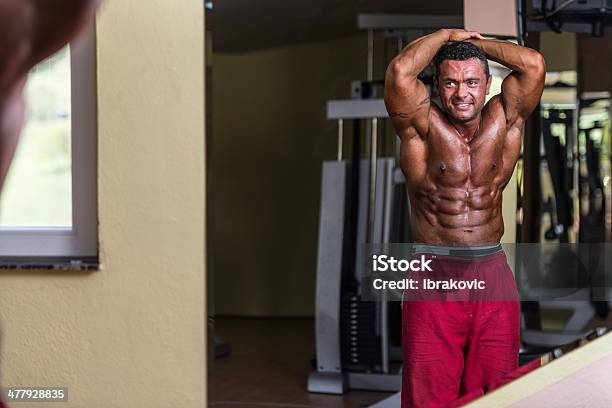 Bodybuilder Muestra Abs En El Gimnasio Foto de stock y más banco de imágenes de Adulto - Adulto, Agarrar, Belleza