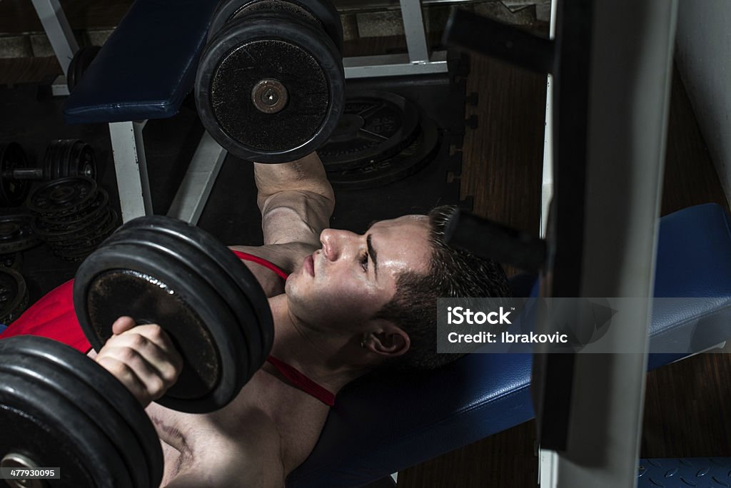 Joven bodybuilder haciendo Prensa de pecho en banco - Foto de stock de Adulto libre de derechos