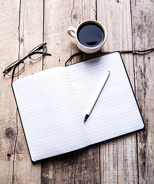 istock glasses on notebook with pen and cup of coffee 477930200
