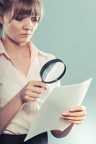 istock woman uses magnifying glass to check contract 477931086