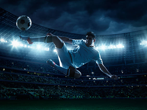 istock Soccer player kicking ball in stadium 477931201