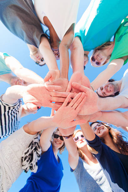 istock Young people holding hands together looking at camera 477936366