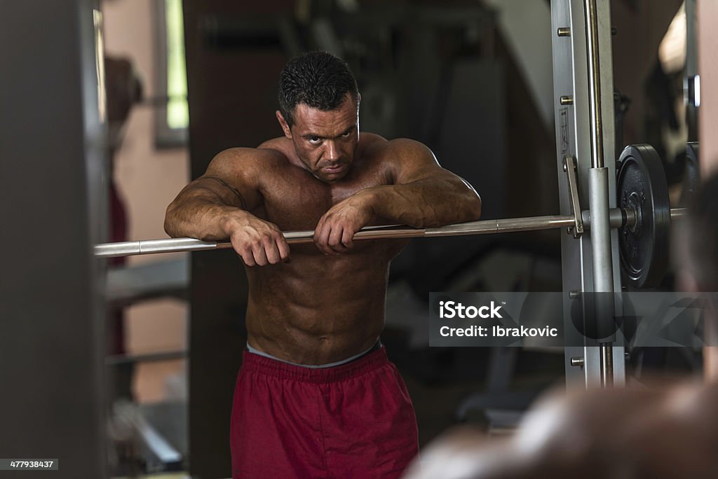 bodybuilder descansando depois de fazer exercícios de peso pesado - Foto de stock de Academia de ginástica royalty-free