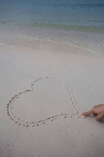 istock hearts drawn on the sand of a beach 477938792