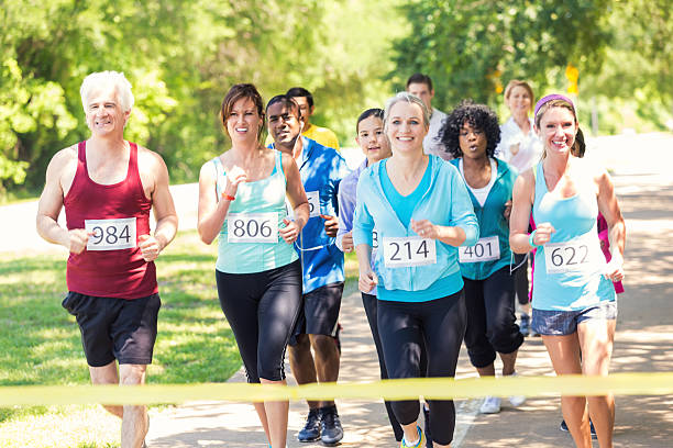 бегунов подъезжая к финишу на марафонской дистанции или забег на 5 км - marathon jogging running finishing стоковые фото и изображения