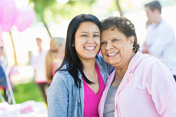 латиноамериканцы пожилая женщина и внучка посещения гонки осведомленности рака молочной железы - grandmother standing senior women senior adult стоковые фото и изображения