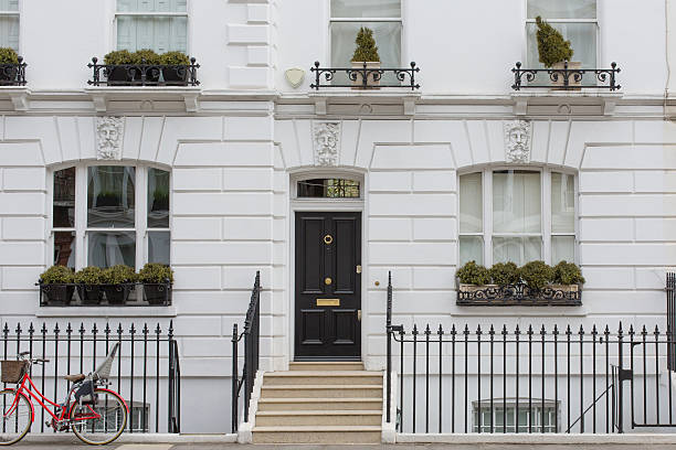 London Home, Chelsea Facade of a Chelsea property with a bike attached to the railings, London kensington and chelsea stock pictures, royalty-free photos & images