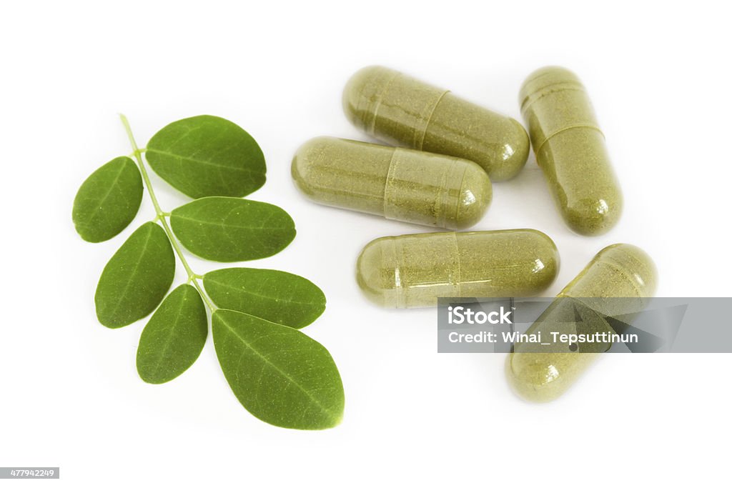 Moringa oleifera capsule with green fresh leaves Moringa oleifera capsule with green fresh leaves on white background Leaf Stock Photo