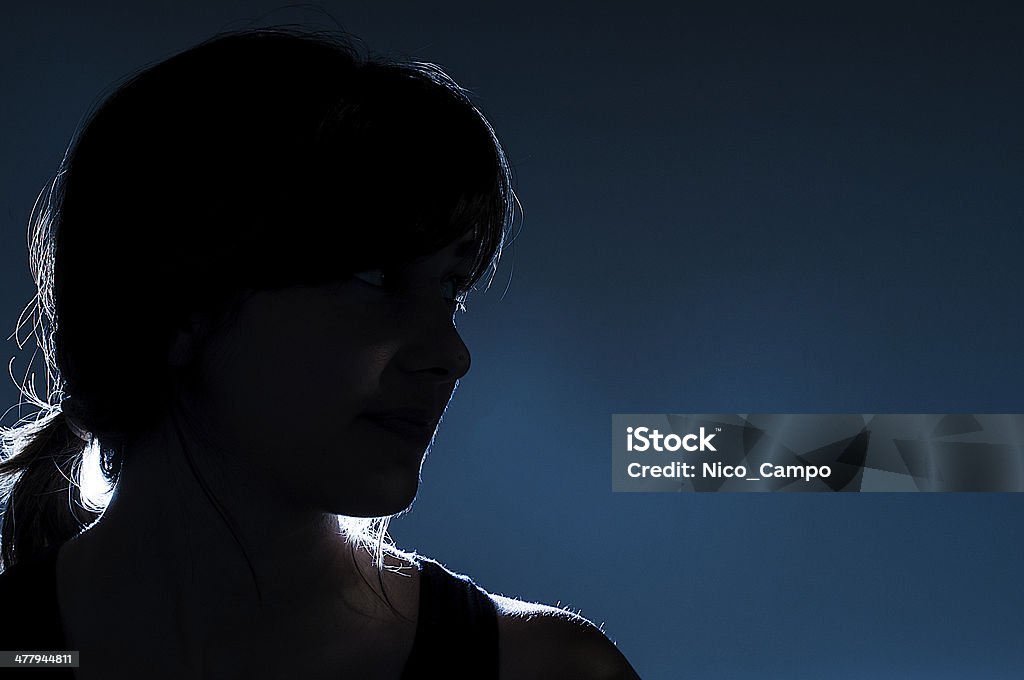 Silhouette on blue background Silhouette of a mysterious girl on blue background Women Stock Photo