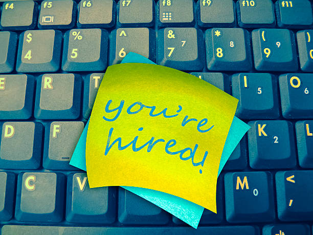 istock Laptop Keyboard with You're Hired note 477947174