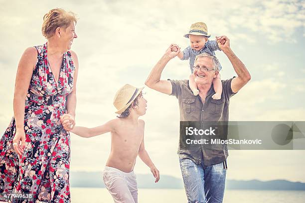 Grandparents And Grandchildren Enjoying Beach Holiday Stock Photo - Download Image Now