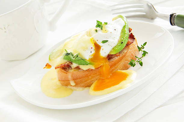 istock Breakfast. Poached egg with hollandaise sauce, bacon and avocado. 477949701