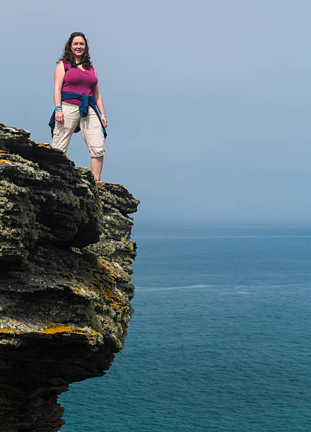 istock Female hiker on cliff edge near Tintagel Cornwall 477949914