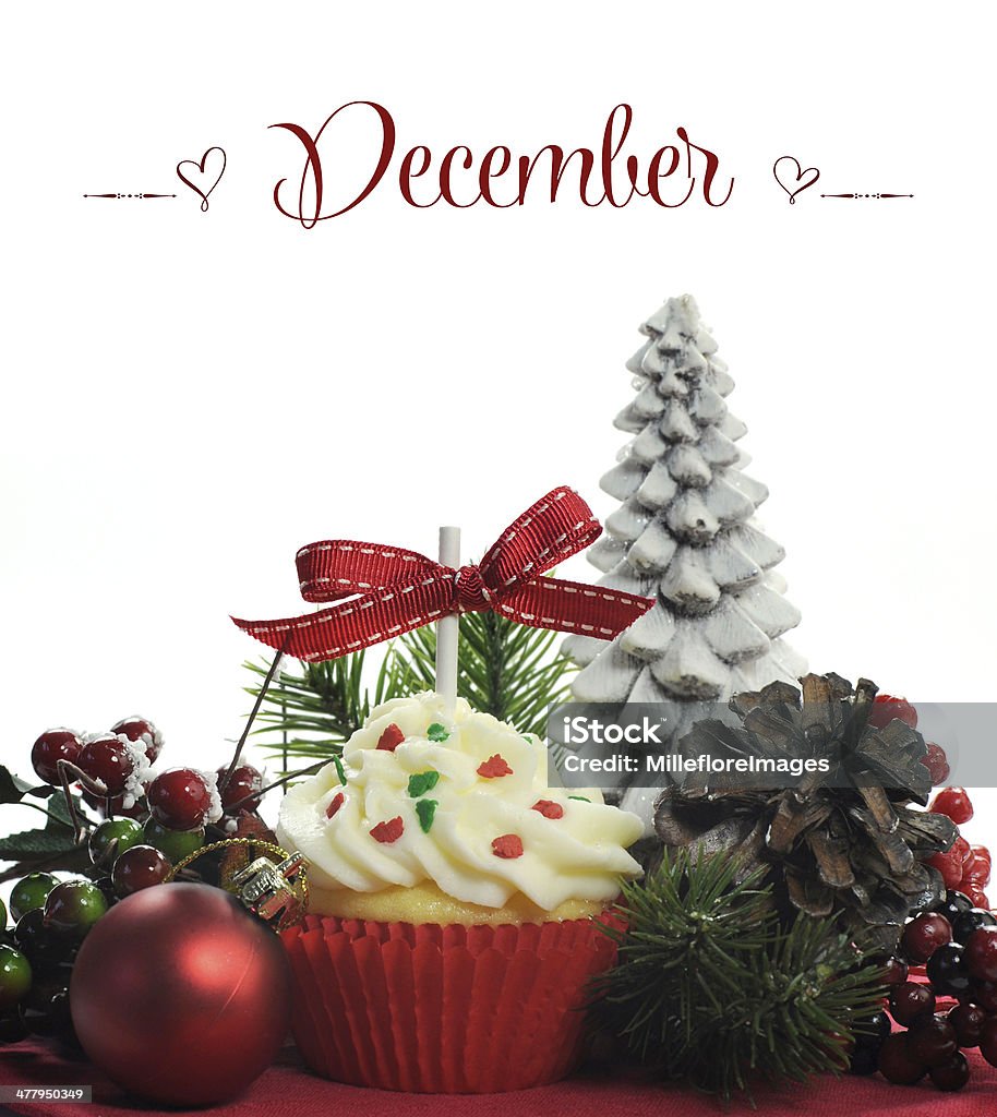 Beautiful Christmas holiday theme cupcake with December sample greeting. Beautiful Christmas holiday theme cupcake with seasonal flowers and decorations for the month of December with sample text or copy space for your text here. Afternoon Tea Stock Photo