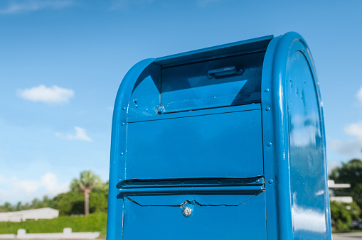 Brand new blue mailbox in a sunny morning day